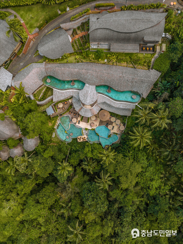 A breathtaking K Club Ubud, revealing its exquisite pool design harmoniously intertwined with lush jungle landscapes, offering guests a refined eco-luxury retreat immersed in the natural beauty of Ubud, Bali.